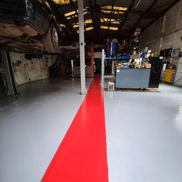 Red epoxy floor paint walkway on grey painted industrial concrete floor