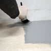 Painting the edges of a floor with a brush